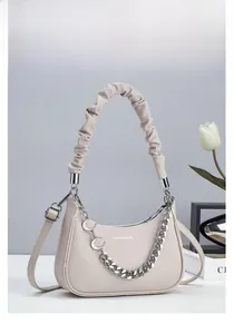 Close-up of beige lychee texture crescent bag featuring a ruched handle and silver chain