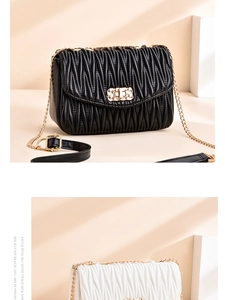 Detail der eleganten Faltenhandtasche mit goldenem Drehverschluss und Kettenriemen