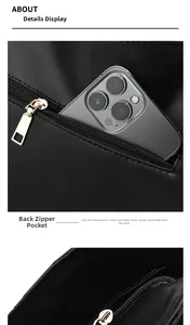 Detail view of the back zipper pocket on a large black faux leather tote handbag
