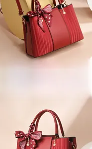 Detail of red leather handbag featuring side vertical texture and silk scarf handle decor