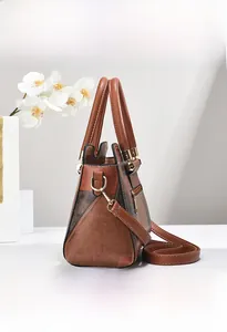 Detail view of caramel brown handbag showing golden hardware and detachable strap