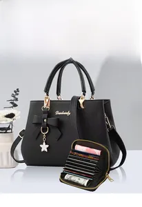 Close-up of black lychee leather tote bag with matching card holder and star charm