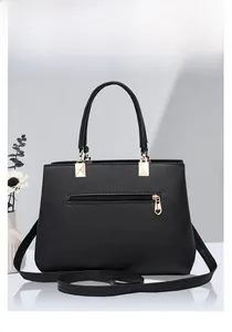 Detail of black pebbled leather tote bag with back zipper and gold heart zipper pull