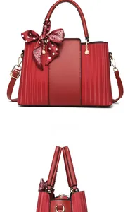 Front and side view of red faux leather handbag with polka dot silk scarf detail