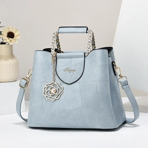 Elegant light blue faux leather handbag with geometric patterns and gold chain handles