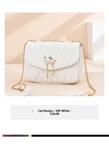 Detaillierte Seitenansicht der cremefarbenen Stepptasche mit Katzenperlen-Deko und Goldkette