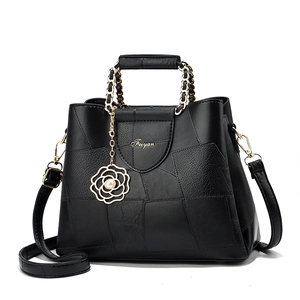 Elegant black crocodile texture handbag with gold chain handle and floral pearl pendant
