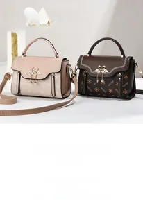 Detailed view of leather handbags with swan metal buckle and pearl pendant detail