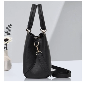 Macro detail of black lychee-grain PU leather tote bag with fine stitching and gold hardware