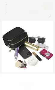 Detail showing high-capacity compartments of a black quilted crossbody bag with gold zippers