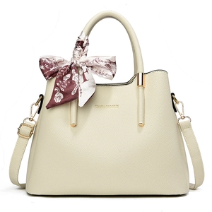 Elegant cream leather handbag with silk scarf handle and golden metal hardware
