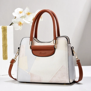 Chic multi-color patchwork shoulder bag with leather handles and spacious interior