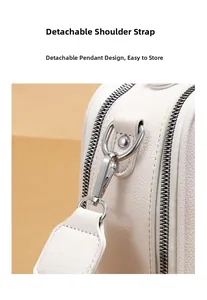 Details der silbernen Beschläge und des abnehmbaren Gurts an cremeweißer Ledertasche