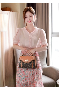 Detailed view of the stylish patterned flap handbag with golden swan buckle and handle