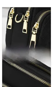 Detailed view of the gold-tone heavy duty zipper and quilted black fabric texture