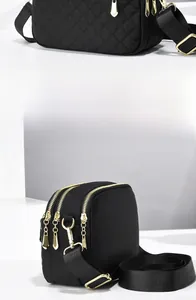 Detail of black nylon crossbody bag with quilted patterns and triple zipper compartments