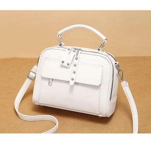 Detailansicht der cremeweißen Handtasche aus Leder mit Litschi-Maserung und Nieten