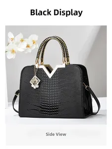 Détail du sac cabas noir gaufré crocodile avec logo V doré et breloque en perles