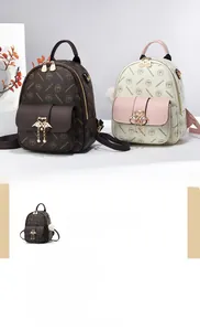 Close-up of vintage patterned PU leather mini backpacks with swan metal charms