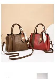 Close-up of stylish faux leather handbags with geometric texture and decorative silk scarves