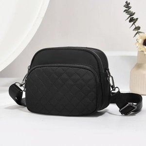 Classic black nylon crossbody bag with quilted lattice stitching and multi-zipper pockets