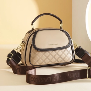 Close-up of beige quilted bucket bag with contrasting brown trim and wide logo strap