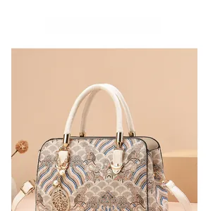 Detail of elegant jacquard handbag with wave patterns, gold hardware and leaf pendant