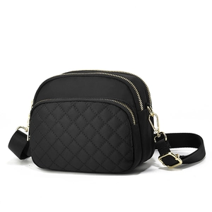 Classic black quilted crossbody bag with multiple gold zippers and adjustable shoulder strap