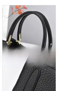 Dettaglio borsa tote in pelle martellata nera con manici tondi e finiture dorate