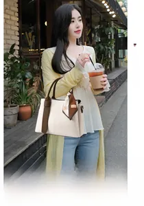 Detail of cream and brown pebbled leather handbag with decorative fashion scarf handle