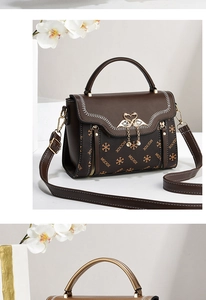 Detail of monogram leather bag with golden swan clasp and contrast stitching