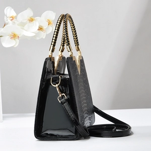Grand sac à main noir motif crocodile avec poignées tressées et boucle dorée en V