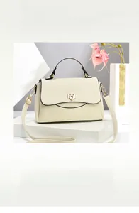 Detail view of cream white leather crossbody bag with golden buckle and sleek black edges