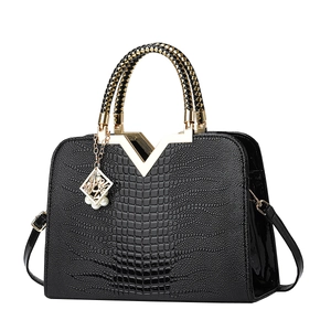 Sac à main noir à motif crocodile avec logo V doré et poignées tressées élégantes