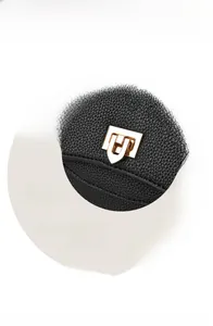 Detailed close-up of the polished gold geometric hardware lock on black lychee leather