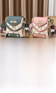 Detail view of mini quilted flap crossbody bags with swan hardware and pearl handles