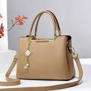 Khaki pebbled leather handbag with gold knot charm and adjustable shoulder strap