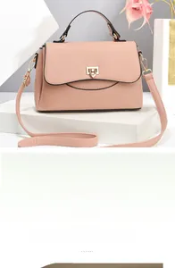 Detail of pink lychee grain leather crossbody bag with golden metal lock and handle