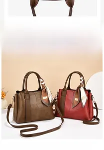 Detail of chic leather tote bags with geometric patchwork and decorative silk scarves