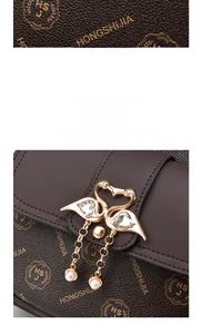 Detail of vintage brown textured backpack with swan buckle and pearl tassel decoration