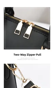 Detail of gold metal hardware showing dual zippers and sturdy side hooks on a black handbag