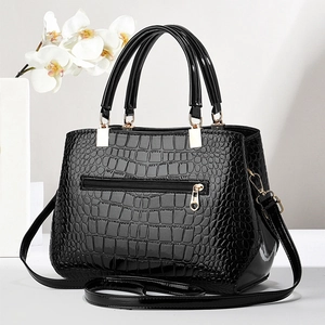 Elegant black crocodile pattern patent leather handbag with gold hardware and shoulder strap