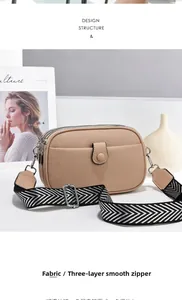 Close-up of three-layer smooth zippers and woven strap on beige pebbled crossbody bag