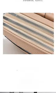 Macro detail of three-layer silver metal zippers on beige lychee grain leather bag