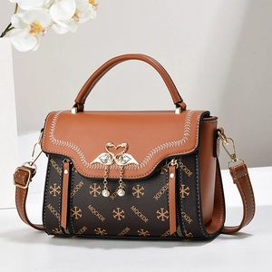 Elegant vintage brown leather handbag with logo pattern and golden swan pearl tassel charm