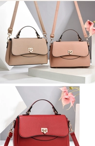 Detail view of khaki, pink, and red pebbled leather crossbody bags with golden buckles