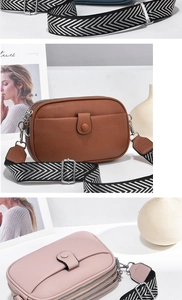 Detail view of small crossbody bag with three-layer zippers and wide woven strap