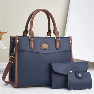 Three-piece women's handbag set in navy blue with brown trim and adjustable shoulder strap
