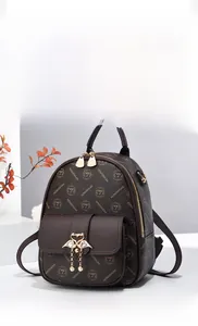 Detailed macro view of the brown leather backpack with golden flamingo buckle and monogram