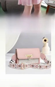 Close-up of pink and white quilted crossbody bag with heart lock and floral strap